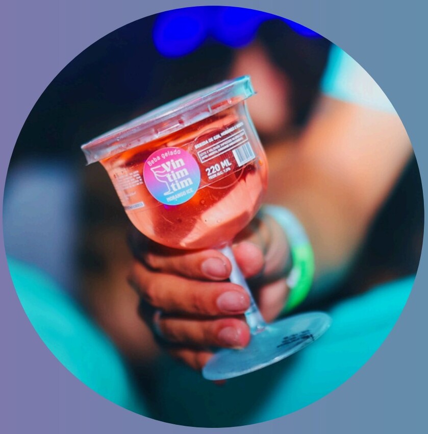 Taça VINTIMTIM com drink rosé sendo servido em evento